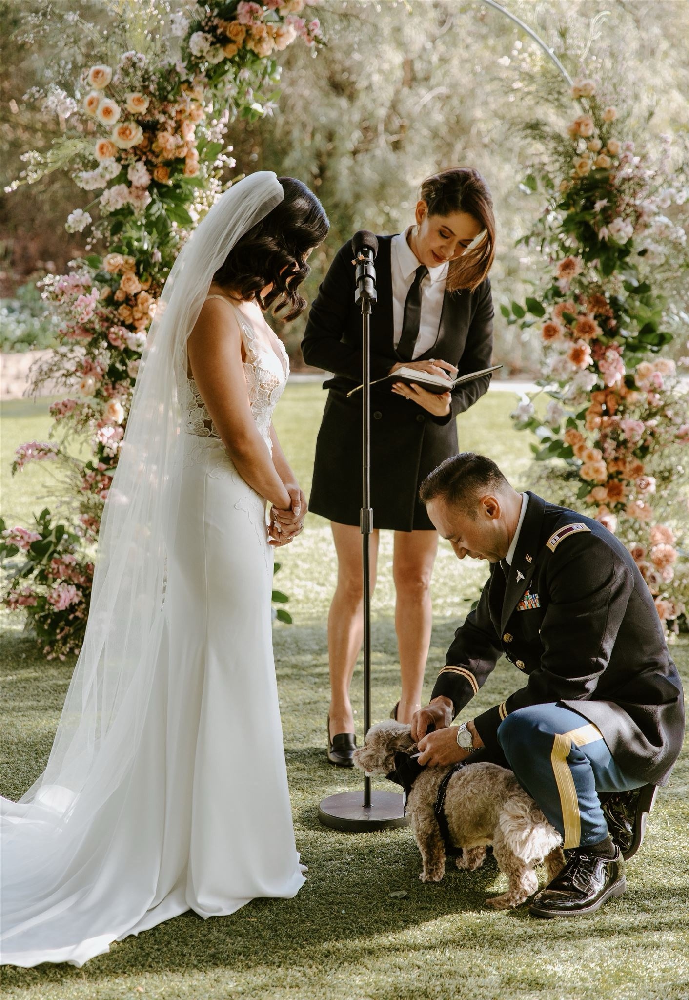 Priscilla with a couple and their dog during their wedding ceremony